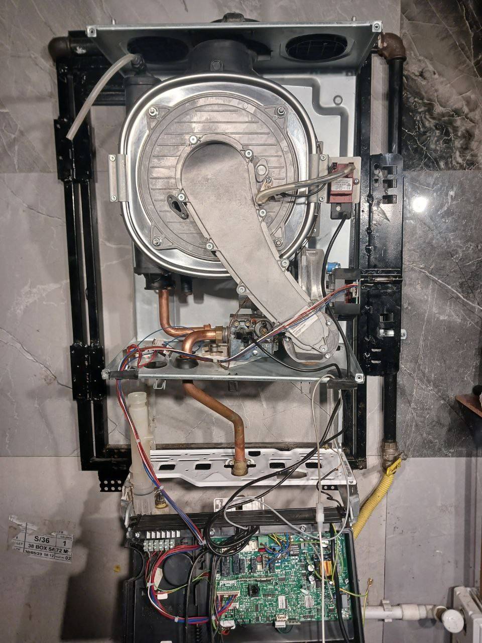 Kapağı açılmış Ariston kombinin alt kısmındaki elektronik kart