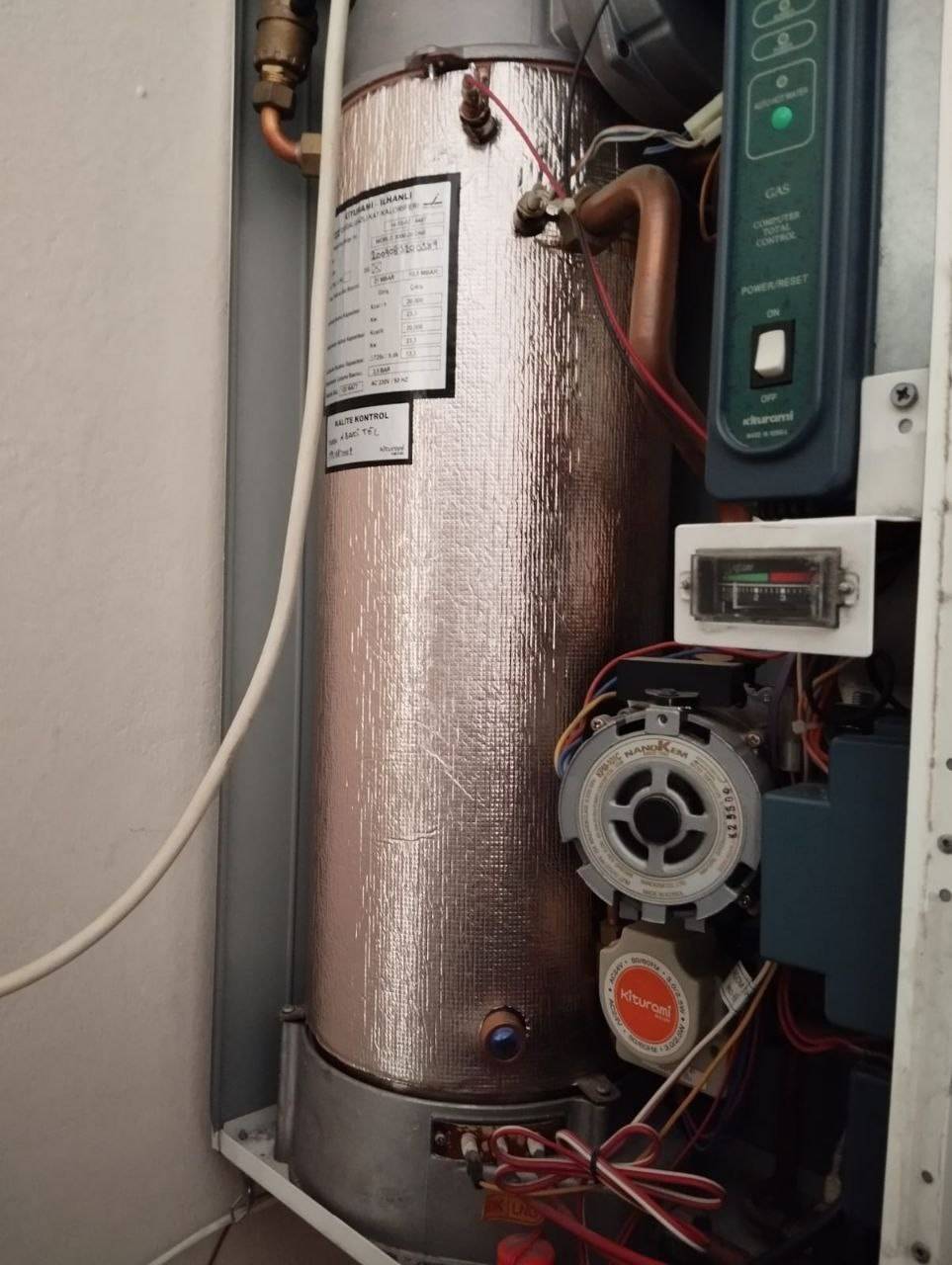 Kapağı açılmış Kiturami kombinin iç aksamı ve kontrol ünitesi